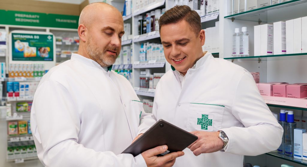Dwóch farmaceutów patrzących w ekran tableta